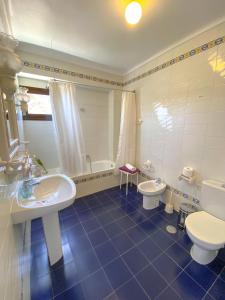 La salle de bains est pourvue de 2 lavabos, de toilettes et d'une baignoire. dans l'établissement La Villa, Alojamiento Rural, à Iznájar