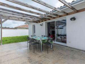 a table and chairs on a patio with a view of the water at Maison climatisée à Parentis-en-Born, 3 chambres, jardin, proche centre et activités, ménage inclus - FR-1-319-554 in Parentis-en-Born