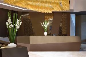 a lobby with a reception desk with flowers and a chandelier at Hilton Bahrain in Manama