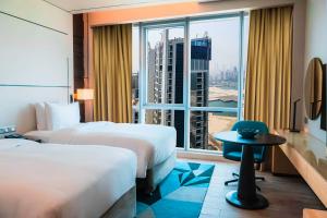 麦纳麦Hilton Bahrain的有两张床和一扇大窗户的酒店房间