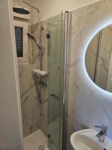 La salle de bains est pourvue d'une douche et d'un lavabo. dans l'établissement Kosovic Family House, à Medulin