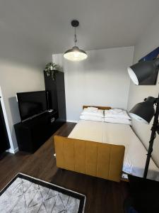 um quarto com uma cama grande e uma televisão em Apartament z tarasem oraz podziemnym parkingiem em Cracóvia