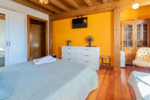 1 dormitorio con cama y pared amarilla en Markiola, en Villamayor de Monjardín