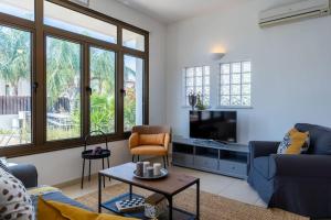 a living room with a couch and a tv at Lumina 2-Bedroom Villa and Pool in Ayia Napa in Ayia Napa