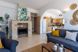 a living room with blue couches and a fireplace at Lumina 2-Bedroom Villa and Pool in Ayia Napa in Ayia Napa
