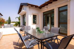 a dining table and chairs on a patio at Lumina 2-Bedroom Villa and Pool in Ayia Napa in Ayia Napa