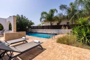 a backyard with a swimming pool and a house at Lumina 2-Bedroom Villa and Pool in Ayia Napa in Ayia Napa