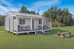 una casetta con un portico in un campo di Madigan Cottages - The Kookaburra Cottage a Lovedale