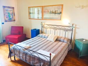 1 dormitorio con 1 cama y 1 silla roja en La quercia di Massena, en Lauria Inferiore