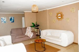 a living room with a couch and a chair at The47 Cozy Cottage in Lilongwe