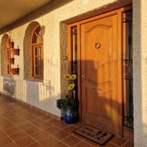 una puerta de madera de una casa con una planta al lado en Villa los Dulces-Piscina Privada, en Letur