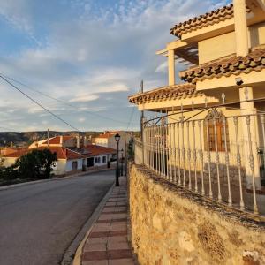a house with a fence on the side of a street at Villa los Dulces-Piscina Privada in Letur