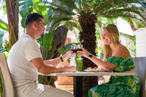 un hombre y una mujer sentados en una mesa bebiendo vino en Carlton Hotel Riviera en Cefalú