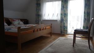 een slaapkamer met een bed en een raam met gordijnen bij Ferienhaus in ruhiger Lage mit großem Garten in Orsingen-Nenzingen