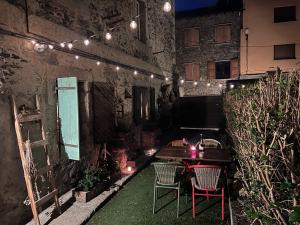a patio with a table and chairs and lights at Cabane Du Cerf in Llivia
