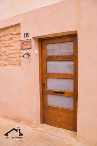 CASA LO PASTELER في Roquetas: باب خشبي في جانب المبنى
