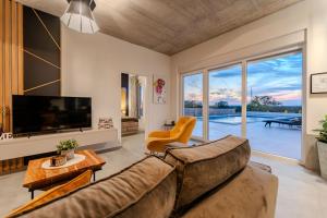 a living room with a couch and a large window at Villa Sunset Grusi ZadarVillas in Briševo