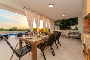 a dining room with a table and chairs at Villa Sunset Grusi ZadarVillas in Briševo