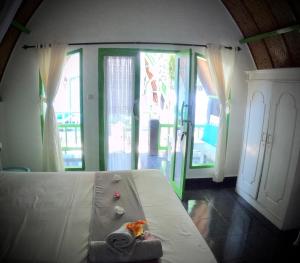 ein Schlafzimmer mit einem Bett mit einem ausgestopften Tier darauf in der Unterkunft Kaktus bungalow 4 in Gili Air