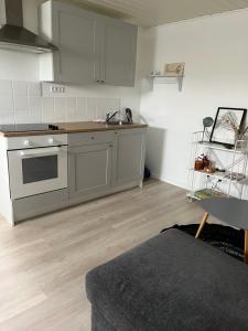 a kitchen with a sink and a stove top oven at Cosy groundfloor apartment in Sørvágur