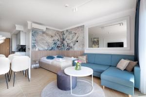 un soggiorno con un divano blu e un letto di Solaris Sea View a Darlowko