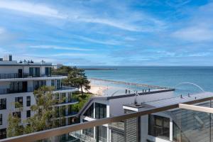 una vista della spiaggia dal balcone di un edificio di Solaris Sea View a Darlowko