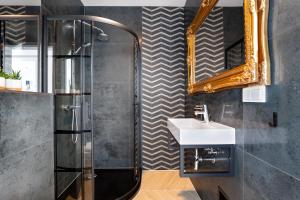 un bagno con doccia, lavandino e specchio di Solaris Sea View a Darlowko Altre 24 foto