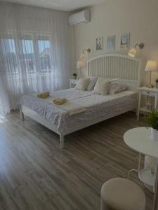 - une chambre avec un grand lit, 2 tables et des fenêtres dans l'établissement Kosovic Family House, à Medulin