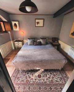 a bedroom with a large bed and a rug at Cabane Du Cerf in Llivia