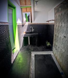 ein Badezimmer mit einem Waschbecken und grünem Licht in der Unterkunft Kaktus bungalow 4 in Gili Air