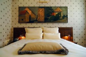 una camera da letto con un grande letto bianco con cuscini di Hotel Mitra, Story Hotels a Ptuj