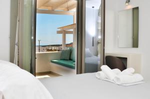a bedroom with a bed and a balcony with a view at Lilian Studios in Koufonisia