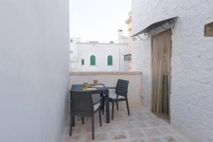Un comedor con una mesa y sillas negras. en Casa Sorrentino, en Cisternino
