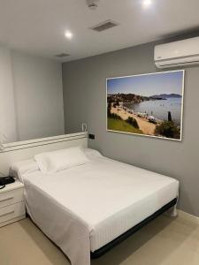 a bedroom with a bed with a picture of a beach at Apartahotel Puerto Blue in Puerto de Mazarrón