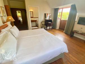 sypialnia z dużym białym łóżkiem i biurkiem w obiekcie Acorn House w Kapsztadzie