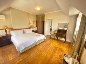 sypialnia z łóżkiem, stołem i lustrem w obiekcie Acorn House w Kapsztadzie