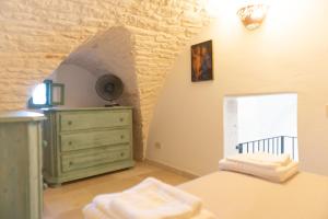 Un dormitorio con una cama y una cómoda y una ventana. en Casa Sorrentino, en Cisternino