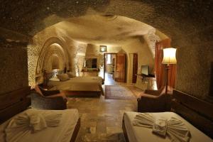 a bedroom with two beds in a stone room at Osmanbey Cave House in Goreme