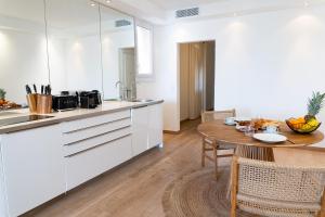 uma cozinha com armários brancos e uma mesa de madeira em Port de Saint-Tropez em Saint-Tropez