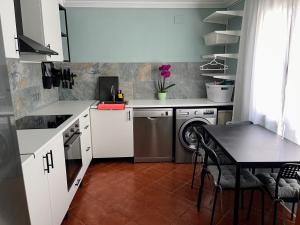 a kitchen with a washing machine and a table at Casa de Gaia in Alicante