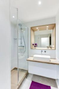 Un baño con lavabo y ducha con espejo. en Le Nénuphar - Parking, Hyper-Centre, 500m Gare, en Cholet