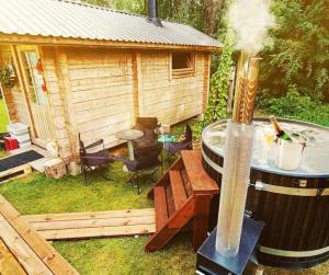 a barrel smoker with a grill and a house at Large Family Apartment ONNELA, Tahko, Palju, BBQ, Sauna, Gym, WiFI, Pets OK, Budget Wanha Koulu Tahkovuori in Reittiö
