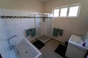 une salle de bain avec une douche, une baignoire et un lavabo dans l'établissement Haus Boost in Swakopmund Central, à Swakopmund 15 autres photos