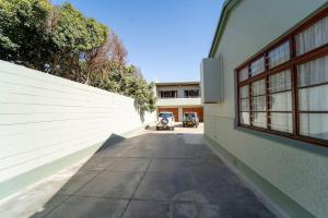 une allée vide menant à un bâtiment avec une voiture au loin dans l'établissement Haus Boost in Swakopmund Central, à Swakopmund