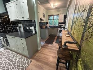 a kitchen with white cabinets and a wooden counter top at Cosy and secluded brook-side lodge in Sleaford