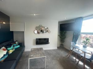 The Marlborough Sea View Holiday Apartments في سكرابورو: غرفة معيشة مع أريكة وطاولة