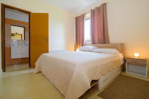 1 Schlafzimmer mit einem großen Bett und einem Badezimmer in der Unterkunft Uliveto Apartment in Fažana
