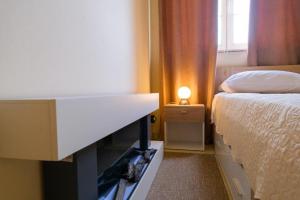 ein Schlafzimmer mit einem Bett und einer Kommode mit einem TV in der Unterkunft Uliveto Apartment in Fažana