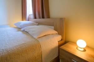 ein Schlafzimmer mit einem Bett und einer Lampe auf einem Nachttisch in der Unterkunft Uliveto Apartment in Fažana