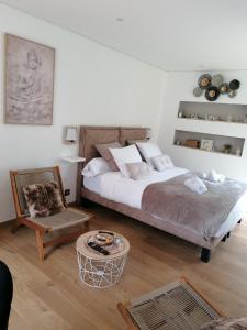 ein Schlafzimmer mit einem Bett, einem Stuhl und einem Tisch in der Unterkunft Aux Charmes de la Vallée in Béthisy-Saint-Pierre